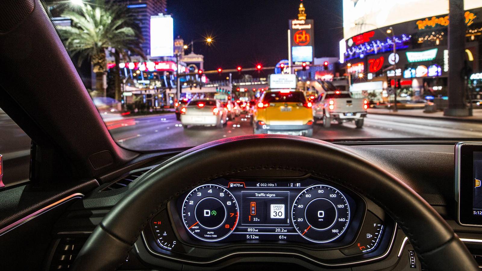 Audi műszerfala a piros lámpára és a sebességkorlátozásra figyelmeztető jelzéssel