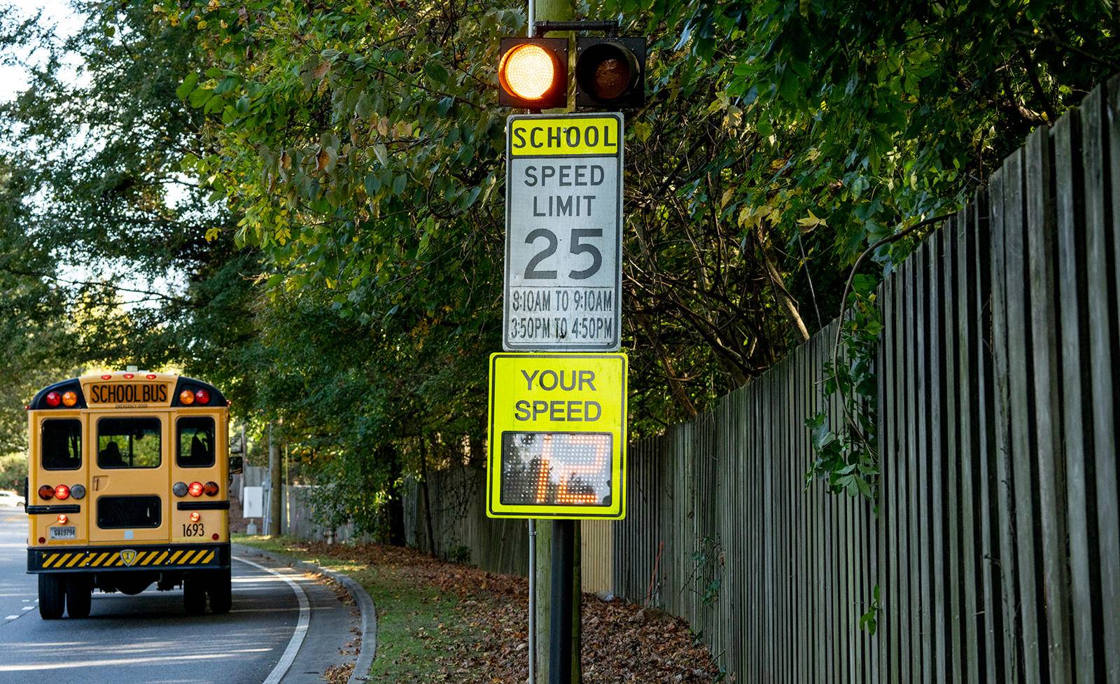 iskolabusz, valamint iskolai övezetre és sebességkorlátozásra figyelmeztető jelzés